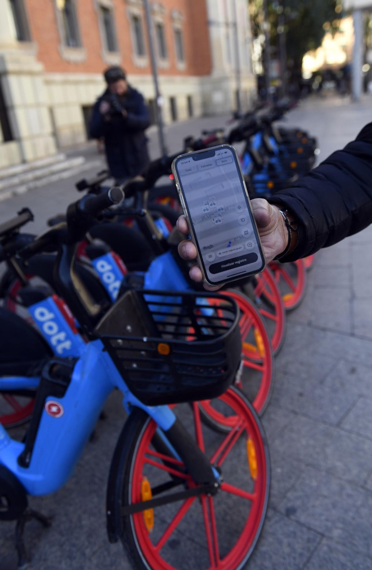 Una persona usa en su teléfono móvil la aplicación 'Dott' que permite activar las bicicletas eléctricas.