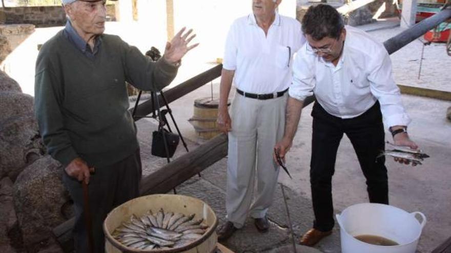 Miguel Pérez (derecha), en una preparación experimental de sardina en el museo de la Salazón.  //  Muñiz