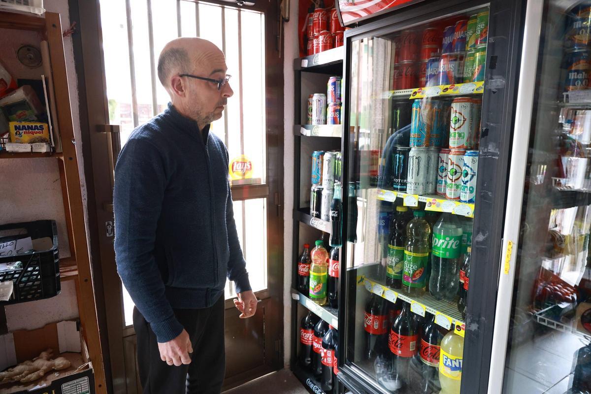 Eduardo, dueño de Multitienda Flippy, en Cáceres, muestra una nevera con bebidas energética.