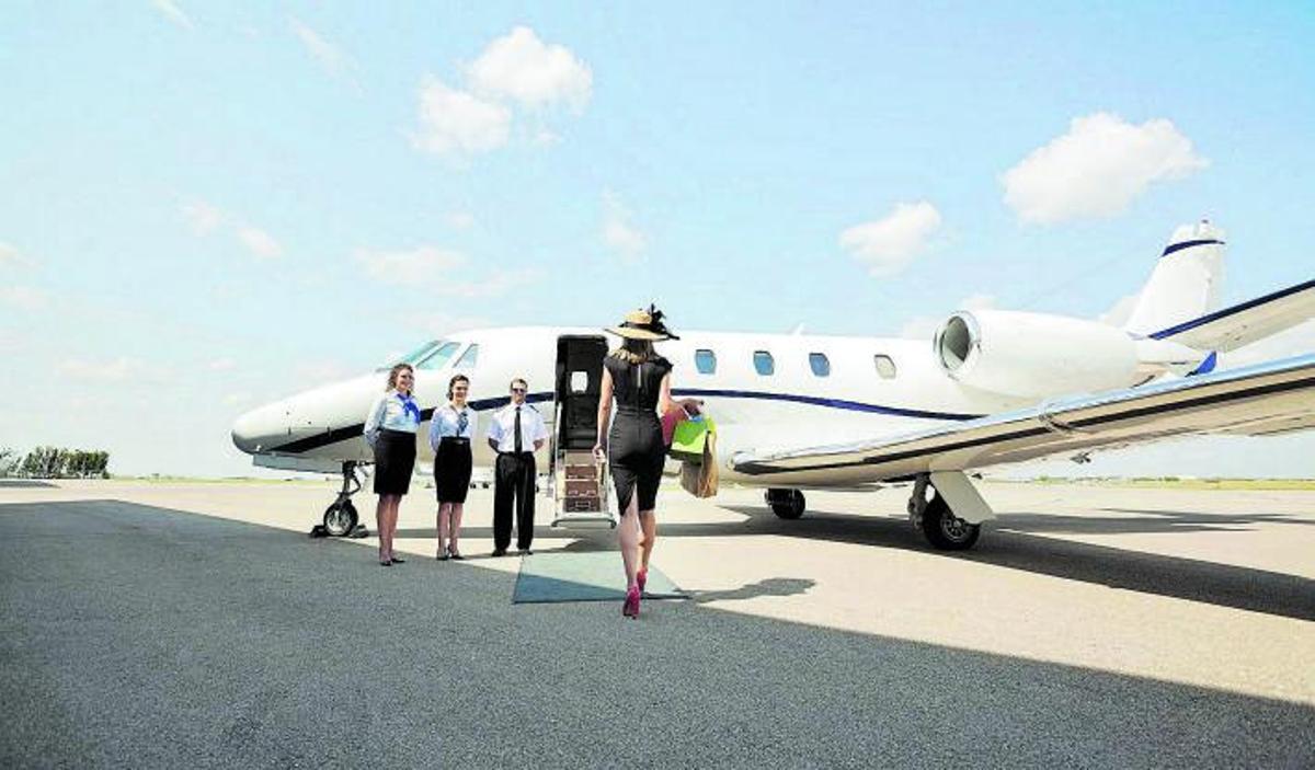 Una pasajera se dirigea su jet privado en la pistadel aeropuerto.  shutterstock