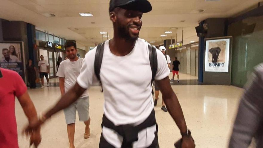 Eliaquim Mangala, sonriente y feliz, a su llegada al aeropuerto de Manises.