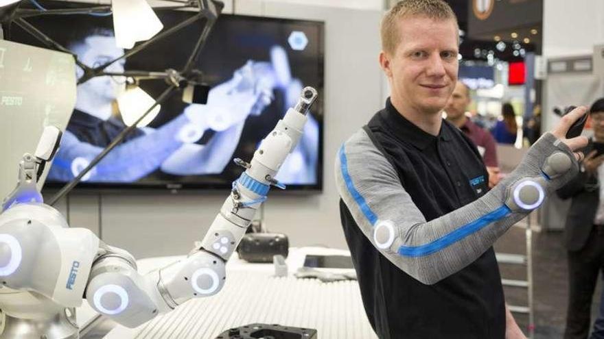 Un técnico muestra un brazo robótico que imita sus movimientos en la Hannover Messe. // Hannonver Messe