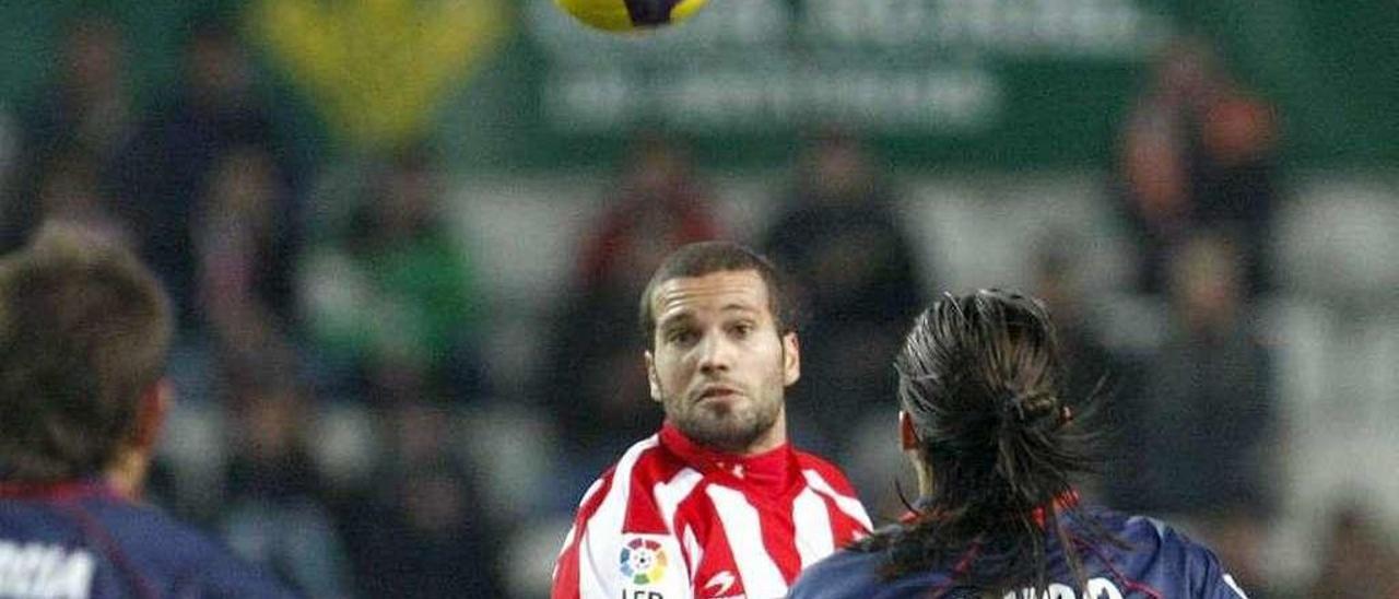 Lora disputa un balón aéreo en un partido entre Sporting y Almería en El Molinón.