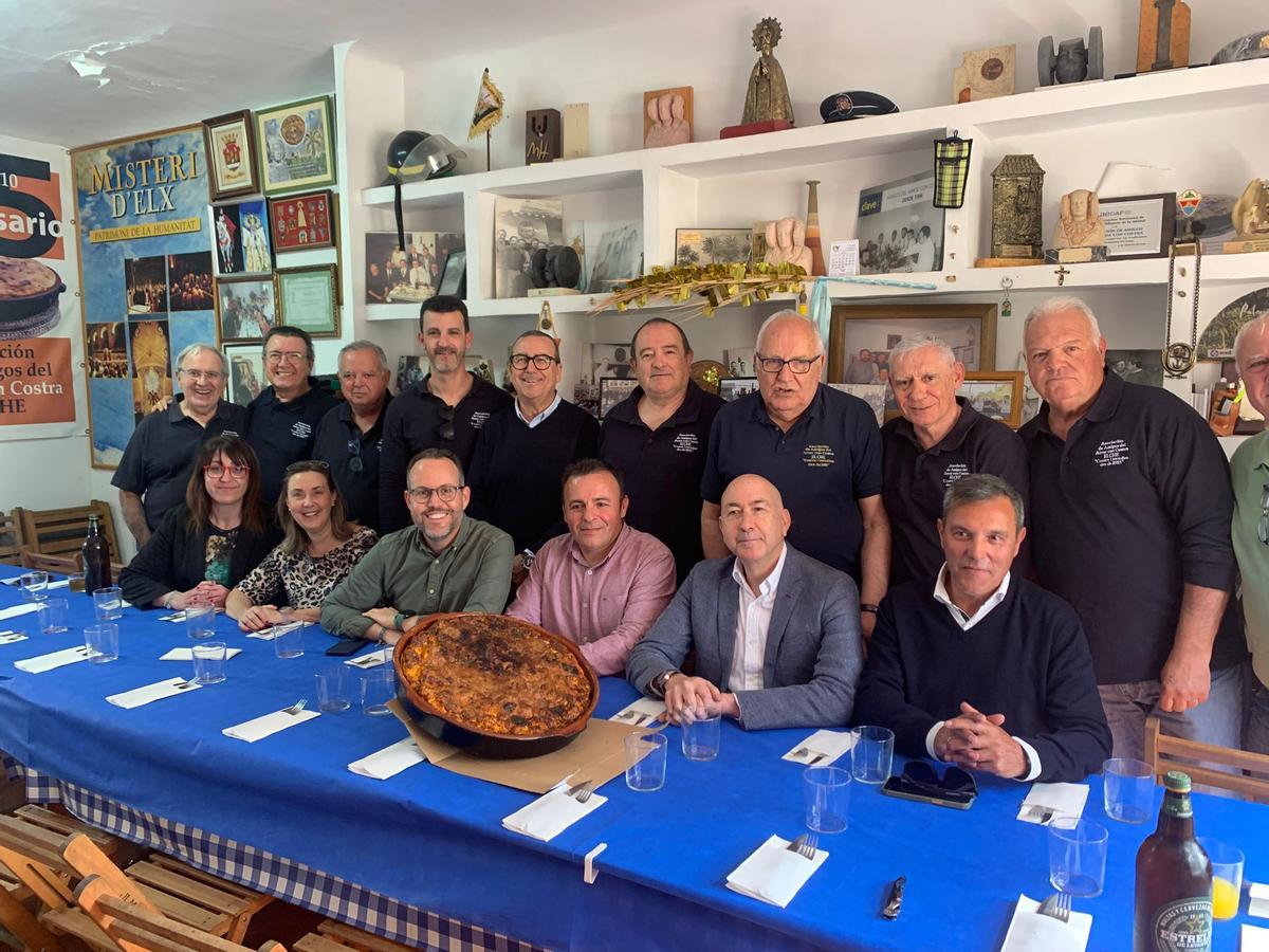 Miembros de la asociación Amigos del Arroz con Costra junto a los políticos del PSOE en Elche