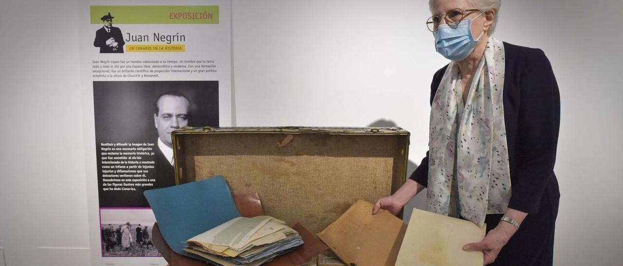 La nieta del doctor Negrín abre y muestra los documentos que han llegado dentro de un baúl con sellos de diferentes países.