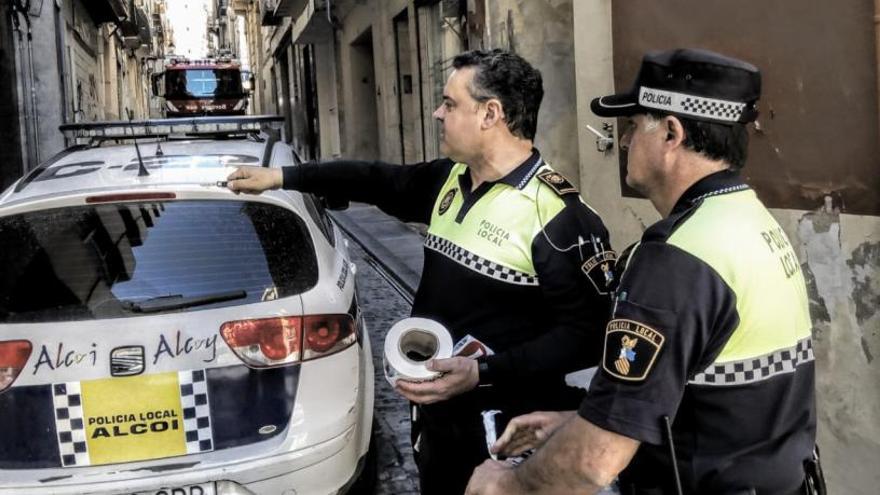 Agentes de la Policía Local cortando el acceso a la calle Sant Francesc con los bomberos al fondo