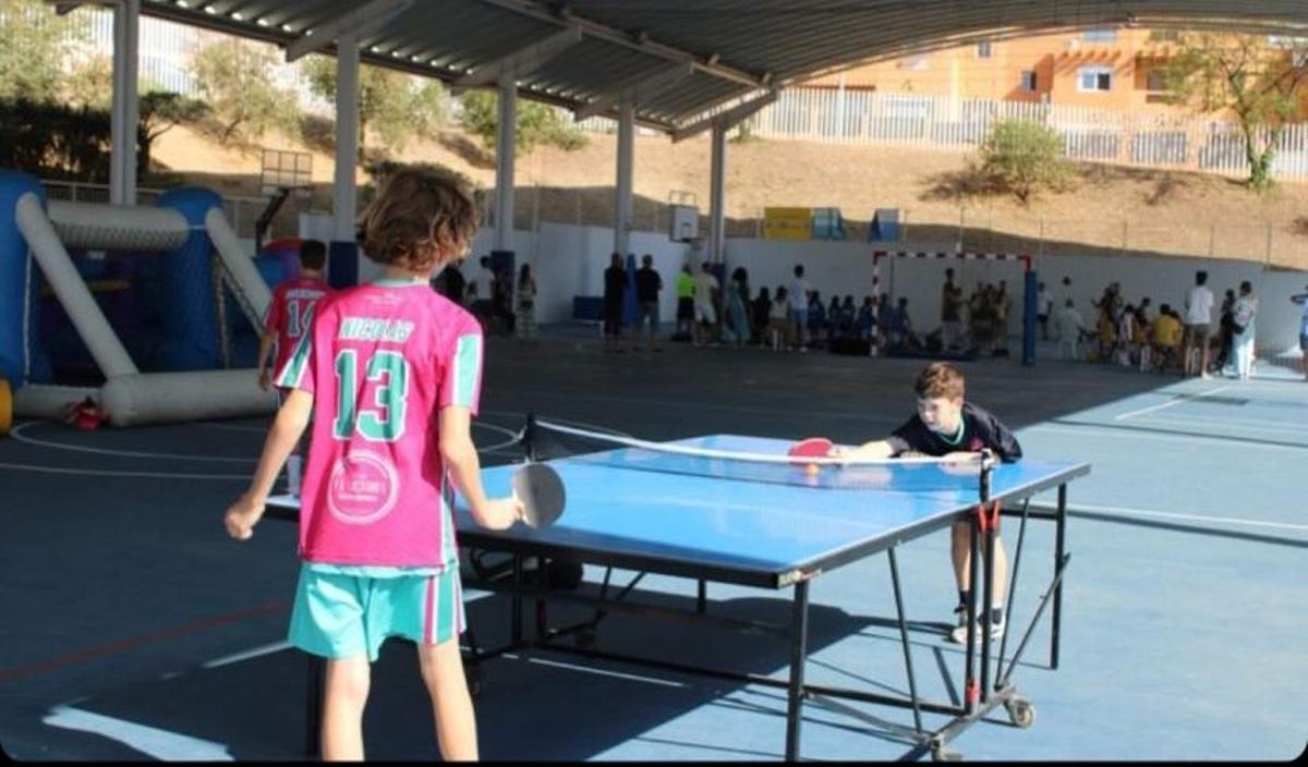 Unos niños juegan al tenis de mesa.