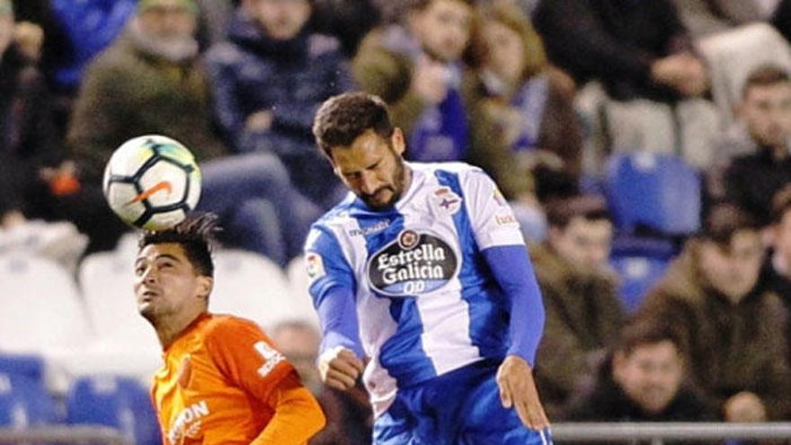 El malaguista Chory Castro salta a cabecear un balón ante Celso Borges, del Deportivo.