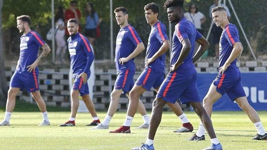 Varios jugadores del Atlético de Madrid realizan estiramientos en su última sesión antes del partido.