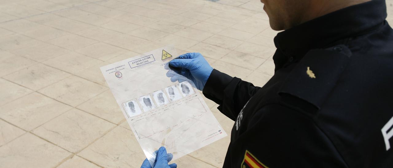 Un agente mira unas huellas en la comisaría provincial de Castellón en imagen de archivo.