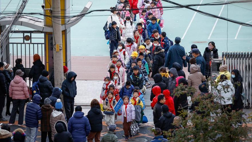 Niños saliendo de un colegio, ayer en Pekín. |   // MARK R. CRISTINO/REUTERS