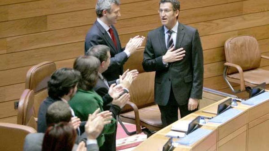 Feijóo recibe, con una mano en el corazón, la ovación de los diputados del PP tras ser investido presidente de la Xunta.