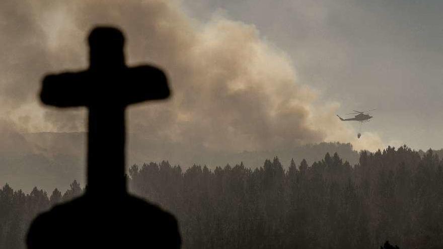 Un helicóptero sofoca las llamas en la localidad ourensana de Nogueira de Ramuín.