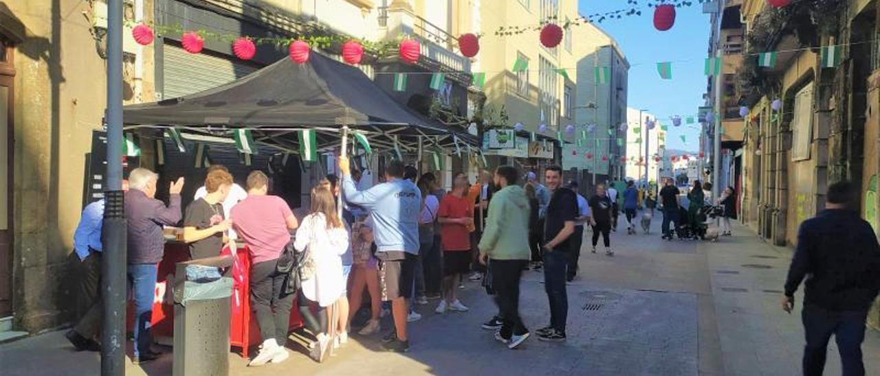 Asistentes al evento entorno a la barra en exterior, para la degustación de rebujitos y pinchos.