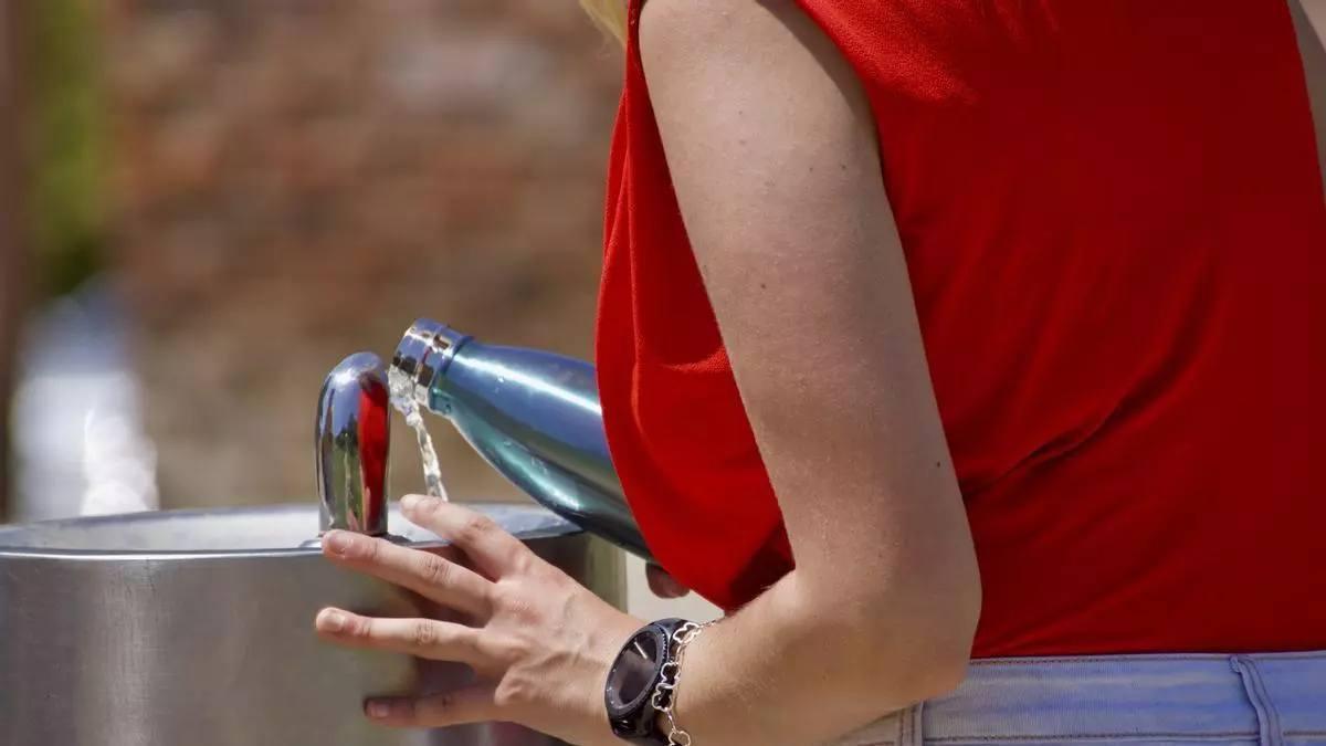 Una persona beu aigua d'una aixeta