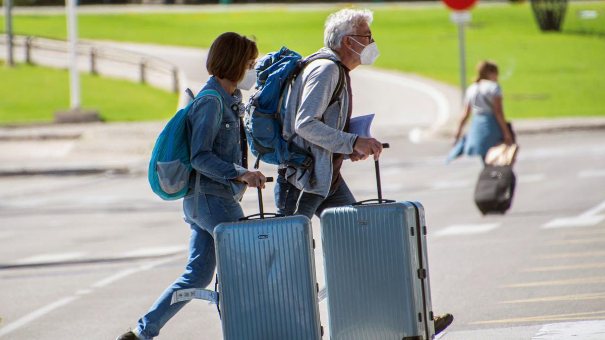 Dos turistas con su maleta.