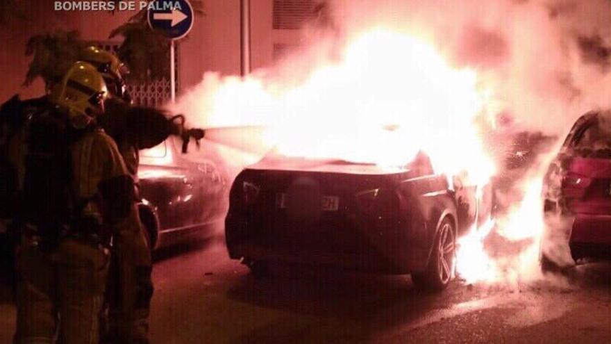 Un bombero sofoca el fuego en un coche esta noche en la calle Pablo Iglesias de Palma.