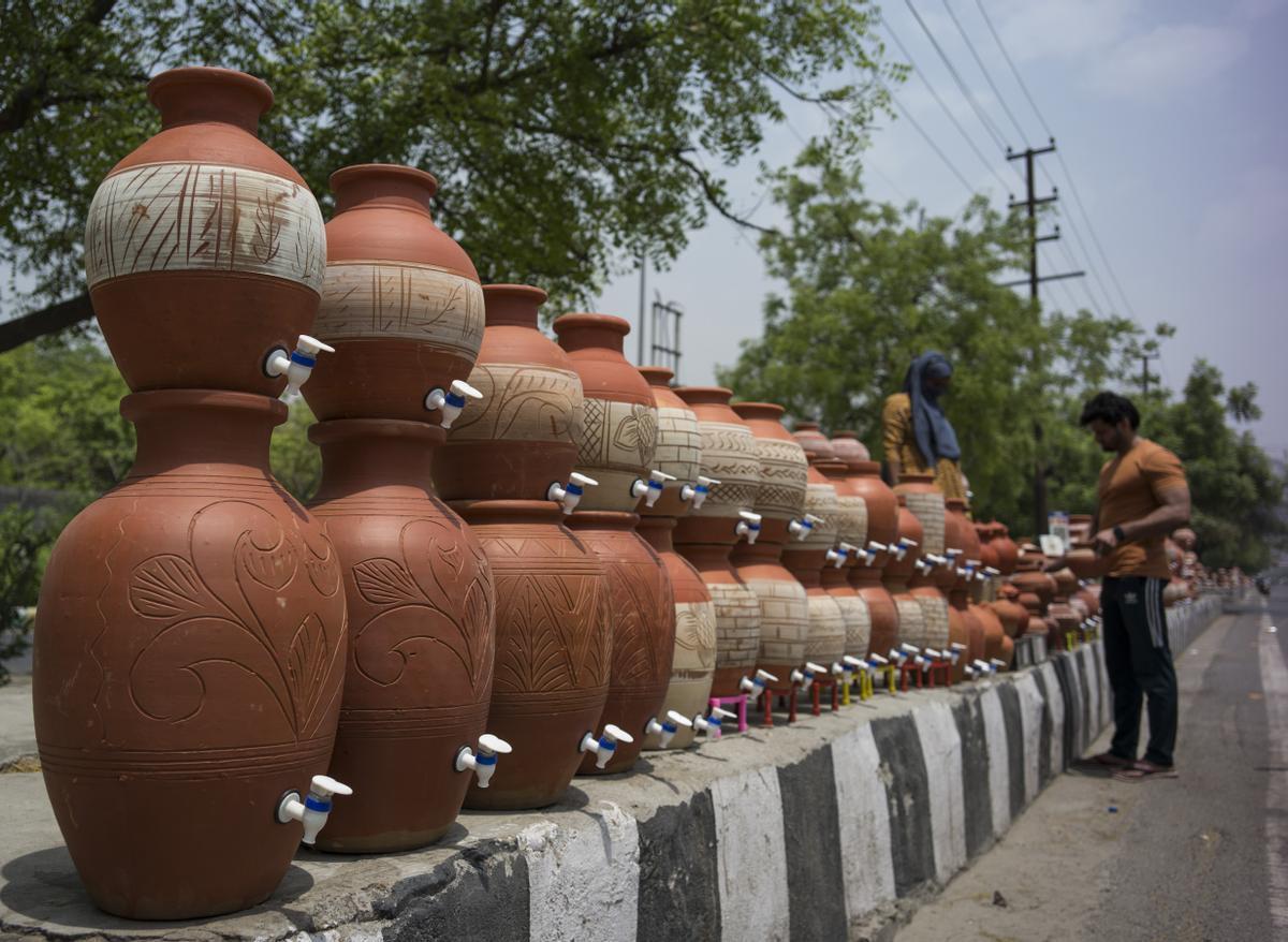 Un hombre compra taros de barro, que se utilizan para mantener el agua fresca, en una calle de Noida, a las afueras de Nueva Delhi.