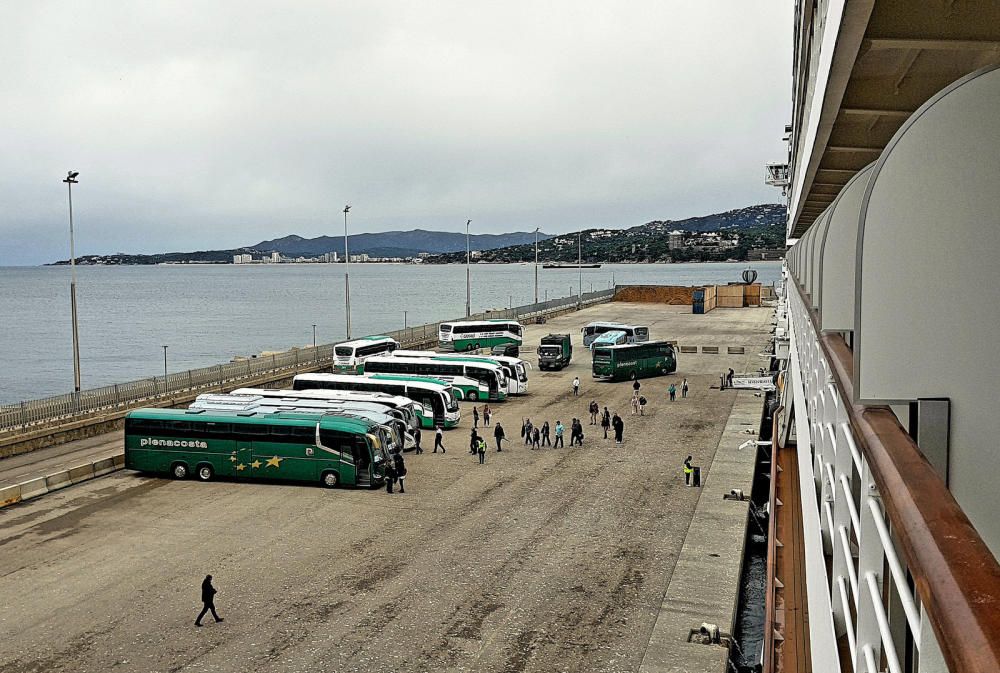 Un quart de nou: els autobusos de les excursions i les furgonetes Mercedes per a les visites privades aparquen al moll, esperant els viatgers.