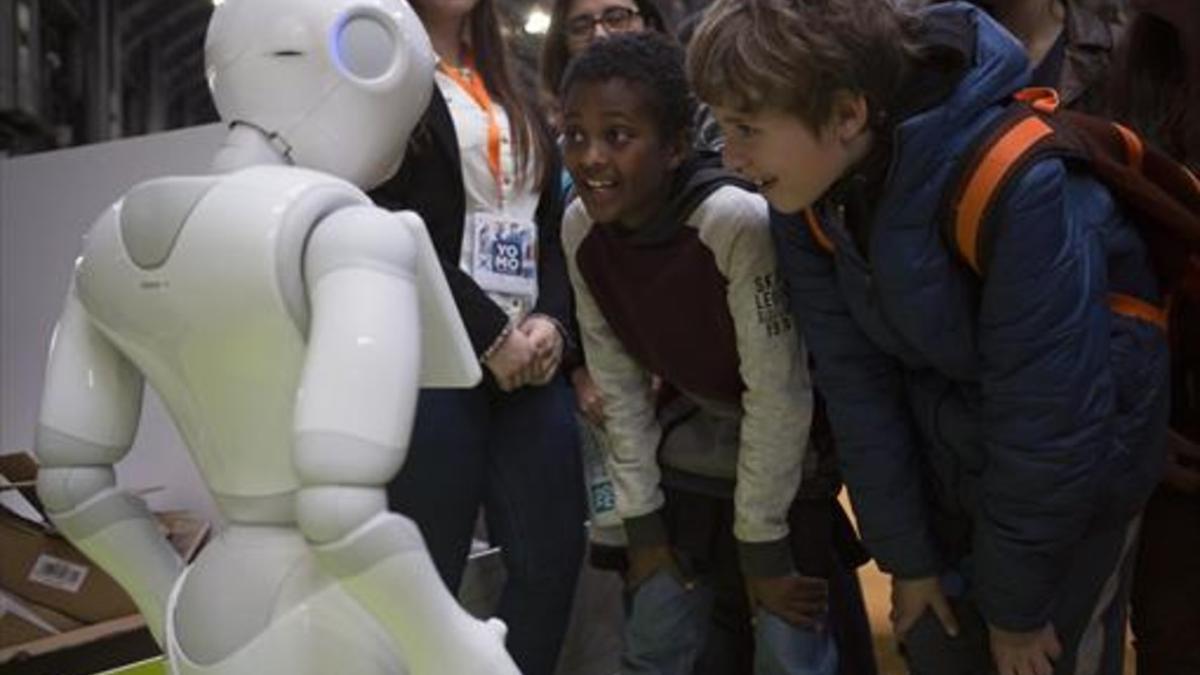 Unos niños observan un robot en el Youth Mobile (YoMo), en el Mobile World Congress.