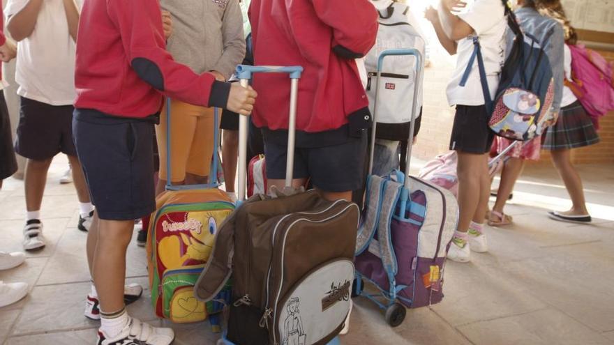 Varios escolares, con sus mochilas.