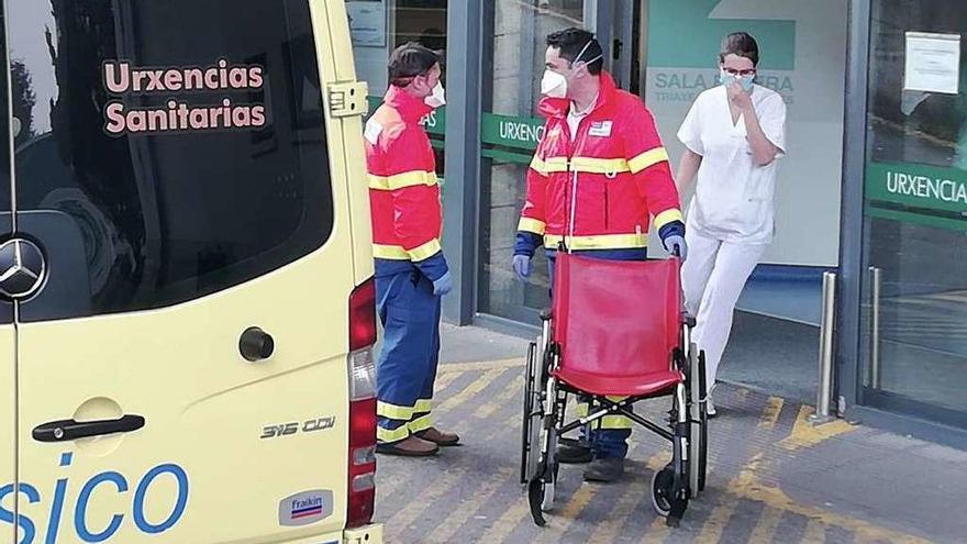 Profesionales sanitarios trasladando pacientes ante la entrada de Urgencias en Montecelo. // Rafa Vázquez