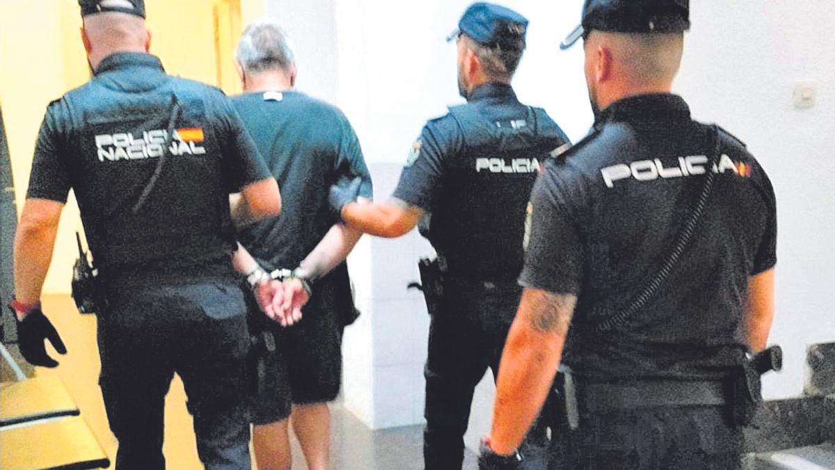 Policías nacionales llevan detenido al presunto atracador de la anciana.