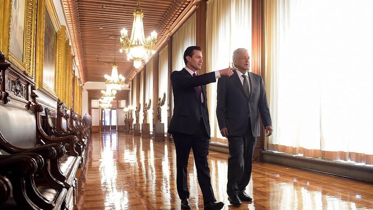 Peña Nieto acompaña a López Obrador por el palacio presidencial.