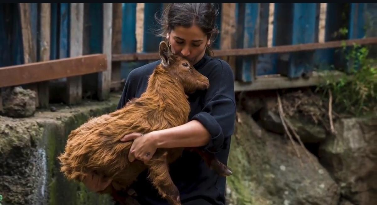 Brenda Rodríguez, en la granja con una de sus cabras.