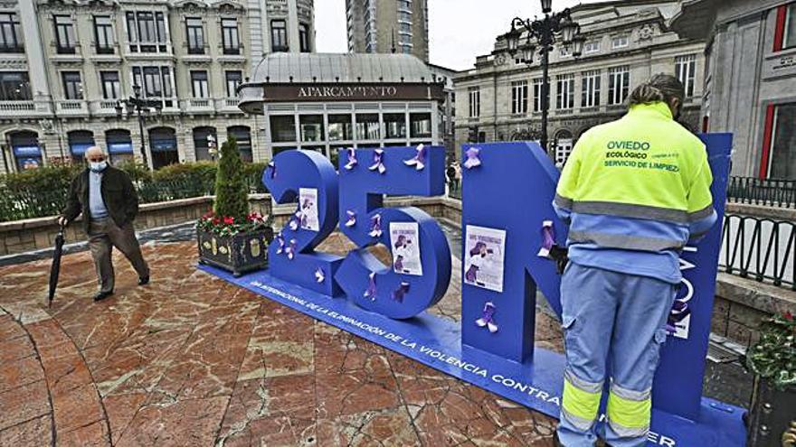 Un operario retira carteles pegados en las letras gigantes del 25-N. | Irma Collín