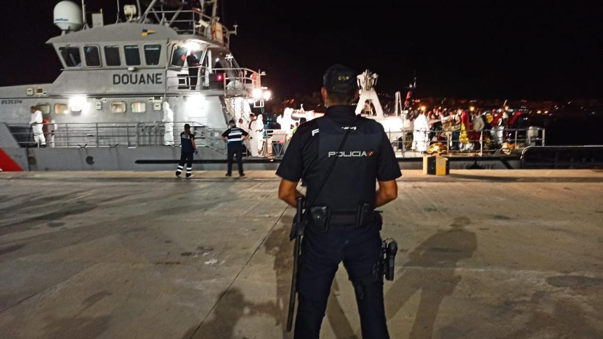 Un policía nacional vigila la llegada de pateras al puerto.