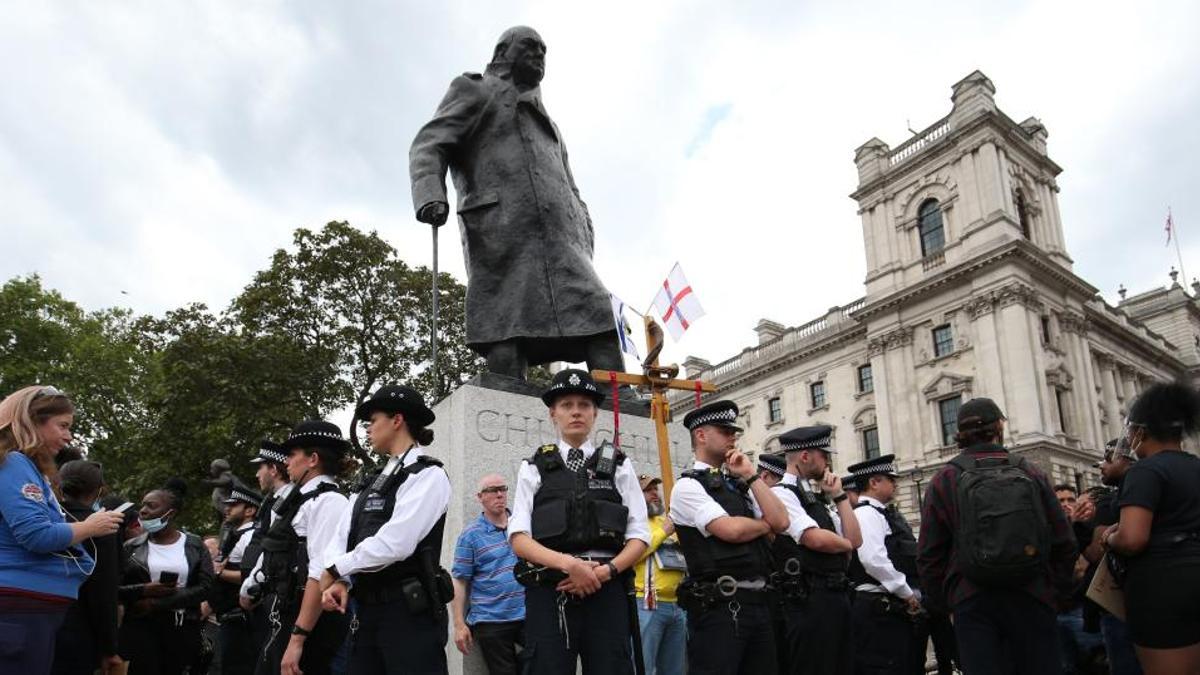 Policías protegen la estatua de Winston Churchill.