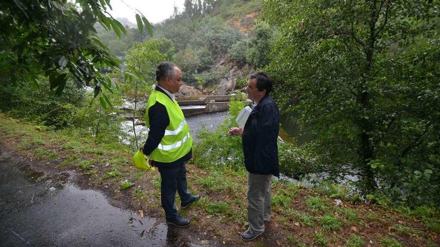 El responsable local de la empresa de aguas y el concejal Raimundo González Carballo, ayer en la presa de Monte Porreiro. // G. Santos