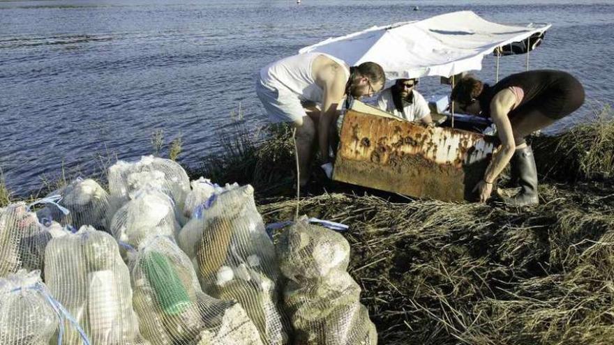 Participantes en la eco-regata retiran residuos, ayer, a orillas de la ría de Betanzos.