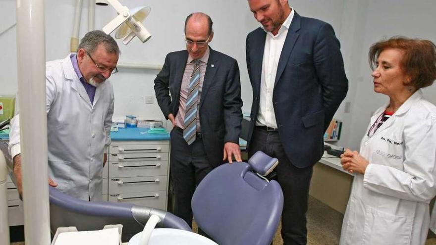 Conselleiro y alcalde, en el actual ambulatorio, viendo la deteriorada silla de Odontología. // Bernabé /C.M.V.