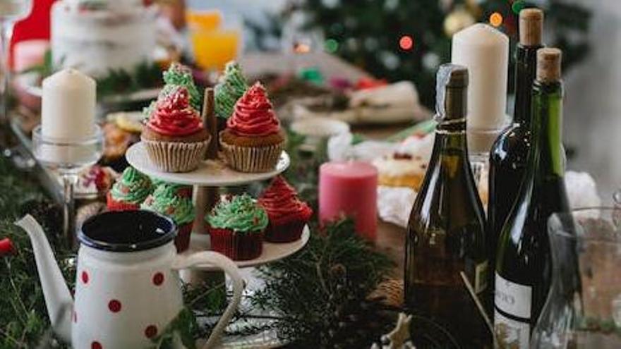Una mesa llena de dulces navideños y vino