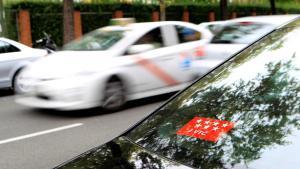 Un taxi pasa junto a un vehículo VTC en una calle del centro de Madrid