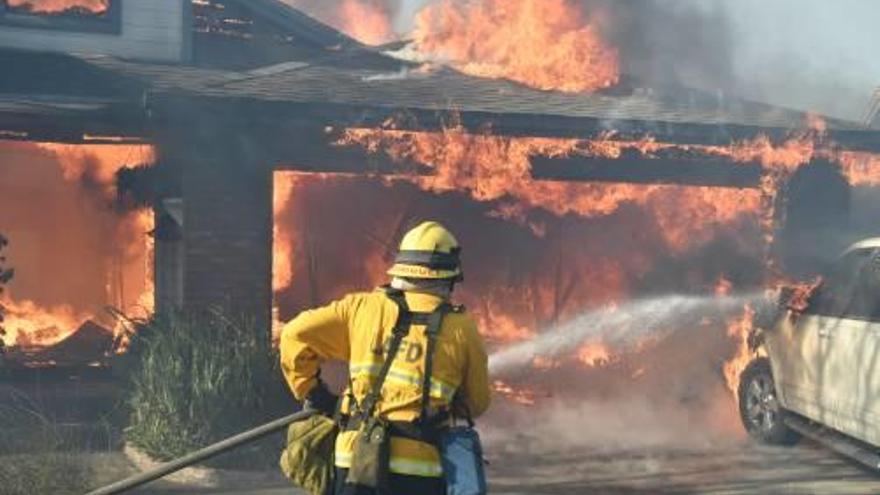 Un bomber lluita contra les flames a Los Angeles.