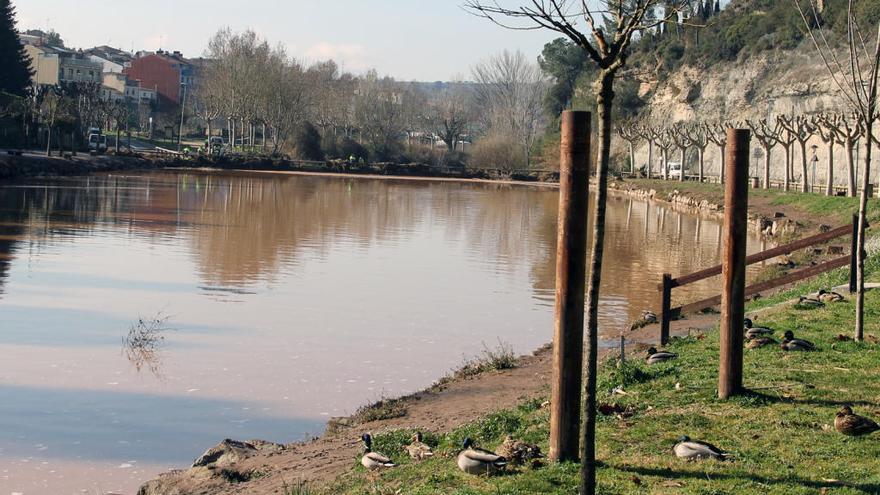 Operaris de la brigada realitzant tasques de neteja al llac, aquest dimecres al matí