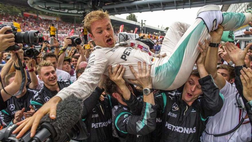 Rosberg, en el aire, celebra su victoria en Monza con los miembros de su equipo.