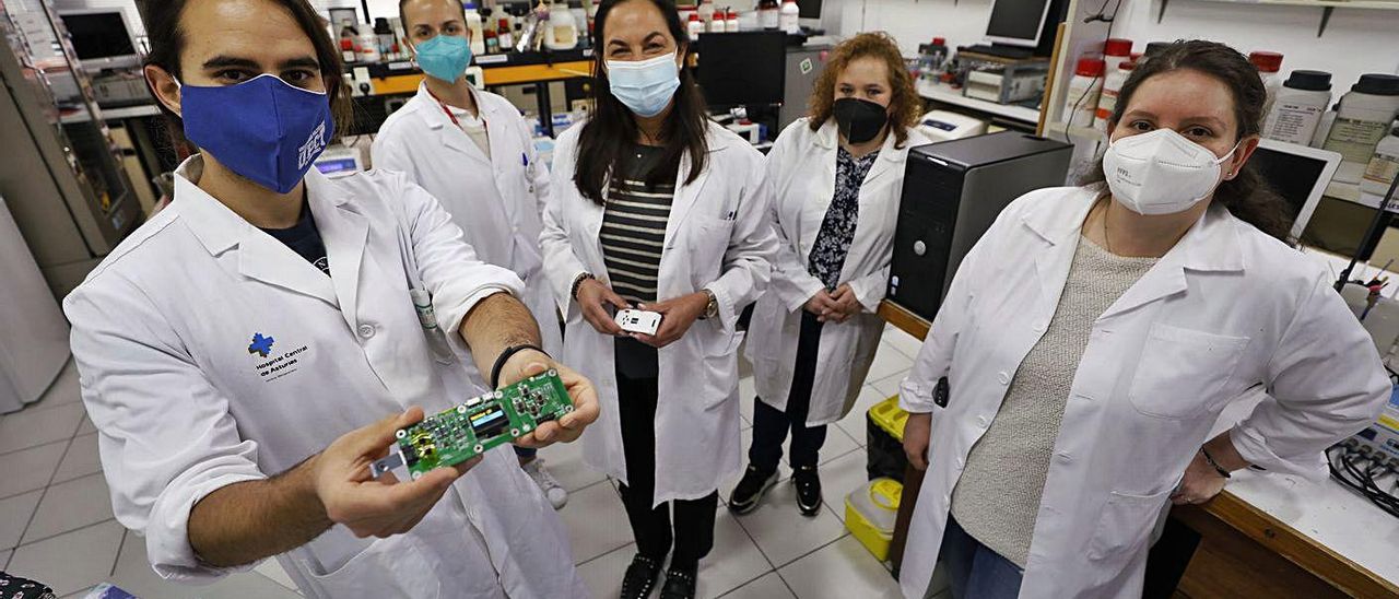 Sobre estas líneas, por la izquierda, José Francisco Beltrán, Andrea González, Teresa F. Abedul, María Dolores Cima y Estefanía Costa, ayer en el laboratorio. A la derecha, González con el detector. | L. Murias