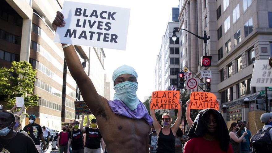 Un manifestante muestra una pancarta en una protesta contra el racismo.