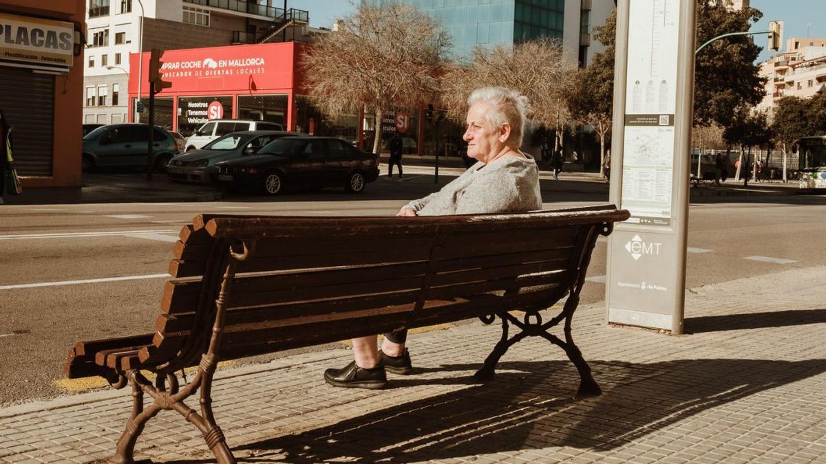 Una mujer mayor toma el sol sentada al aire libre el primer día sin mascarillas en Palma. | BERNARDO ARZAYUS