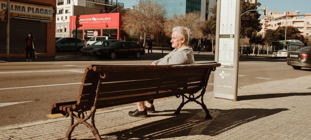 Una mujer mayor toma el sol sentada al aire libre el primer día sin mascarillas en Palma. | BERNARDO ARZAYUS
