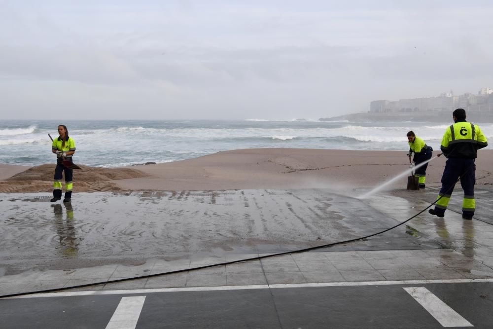 El mar empuja arena al paseo, cortado al tráfico