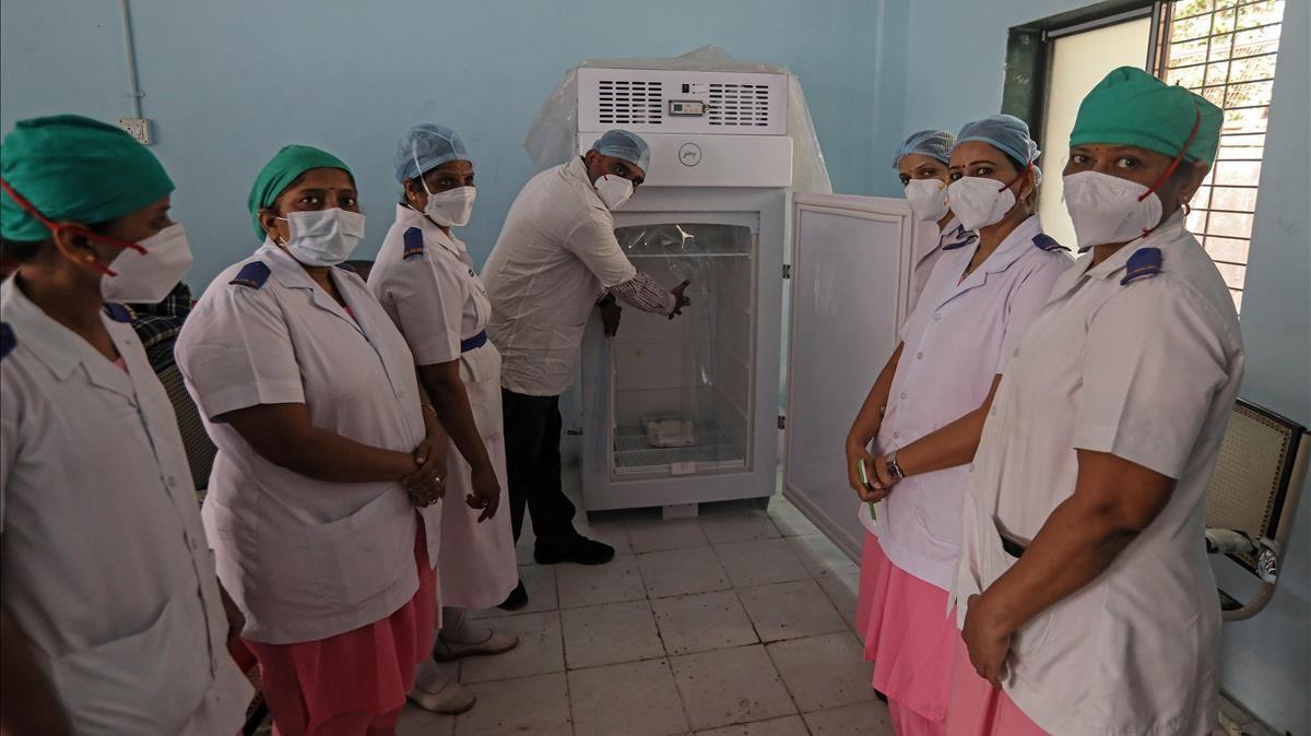 Un grupo de sanitarios posa junto a un refrigerador acondicionado para mantener las vacunas del covid-19 en el Hospital Rajawadi de Bombai. EFE EPA DIVYAKANT SOLANKI