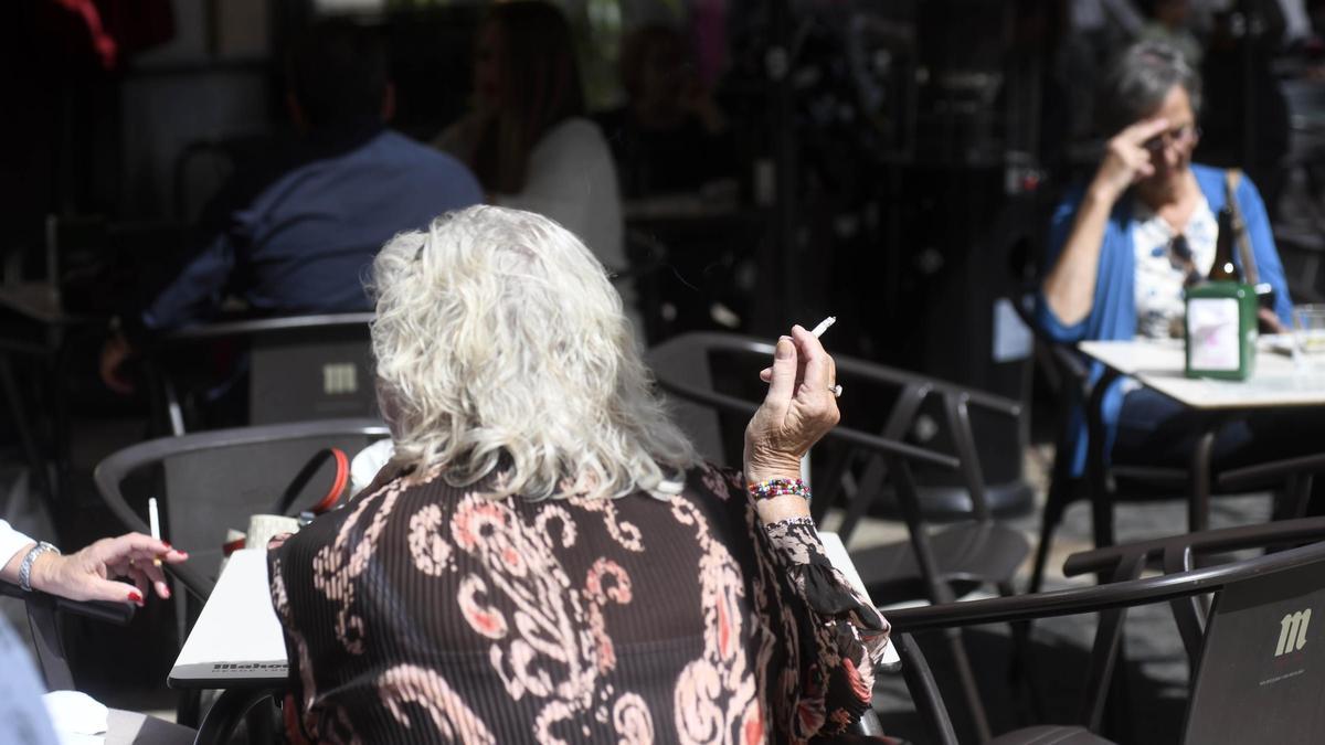 Una mujer fuma un cigarro en una terraza en Murcia.