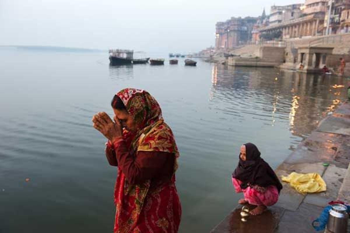 Mujeres rezando al amanecer en la orilla del Ganges.