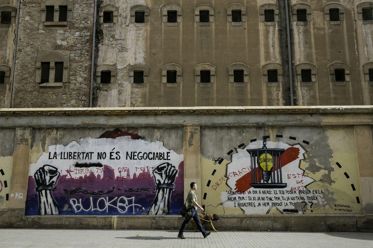 Artistas urbanos pintan los muros de la cárcel Modelo de Barcelona.