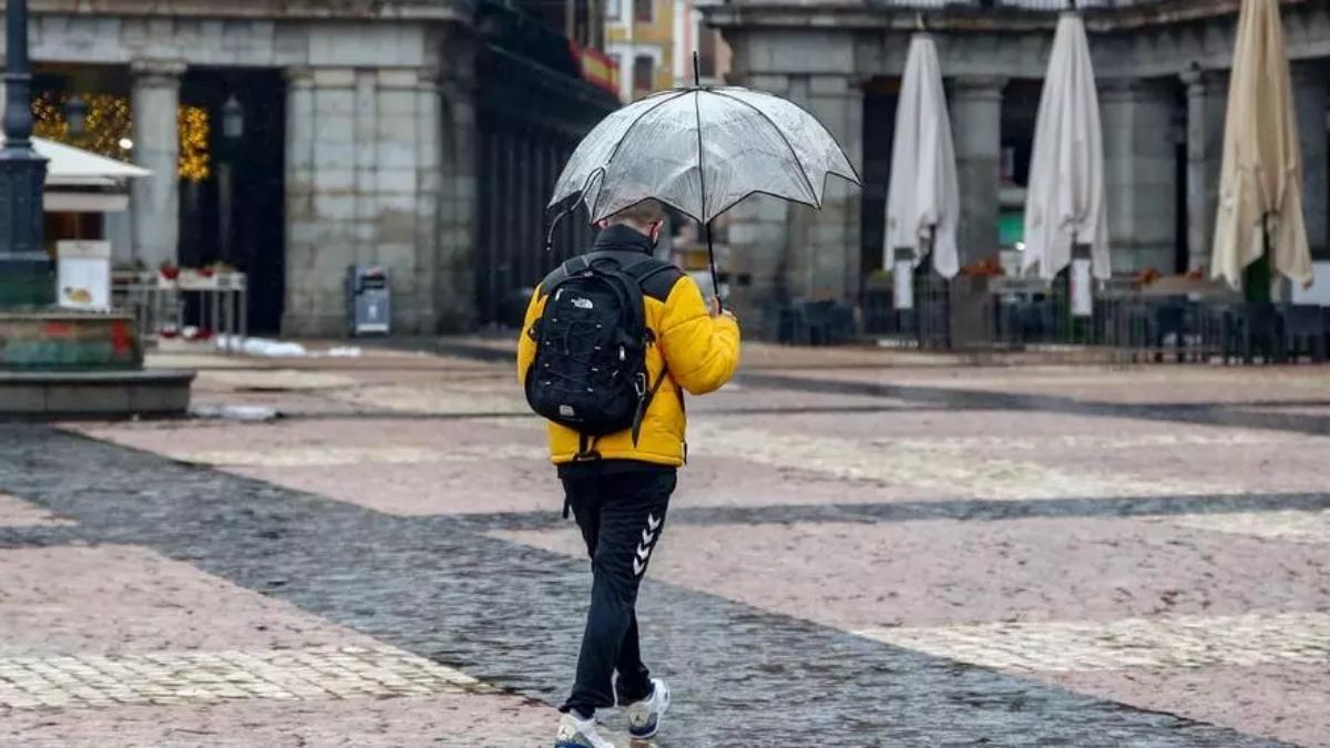 lluviasUn hombre camina protegido por un paraguas